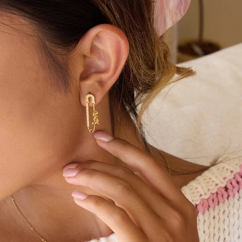 Pendientes dorados LOVE en forma de imperdible con circonitas – Acero inoxidable